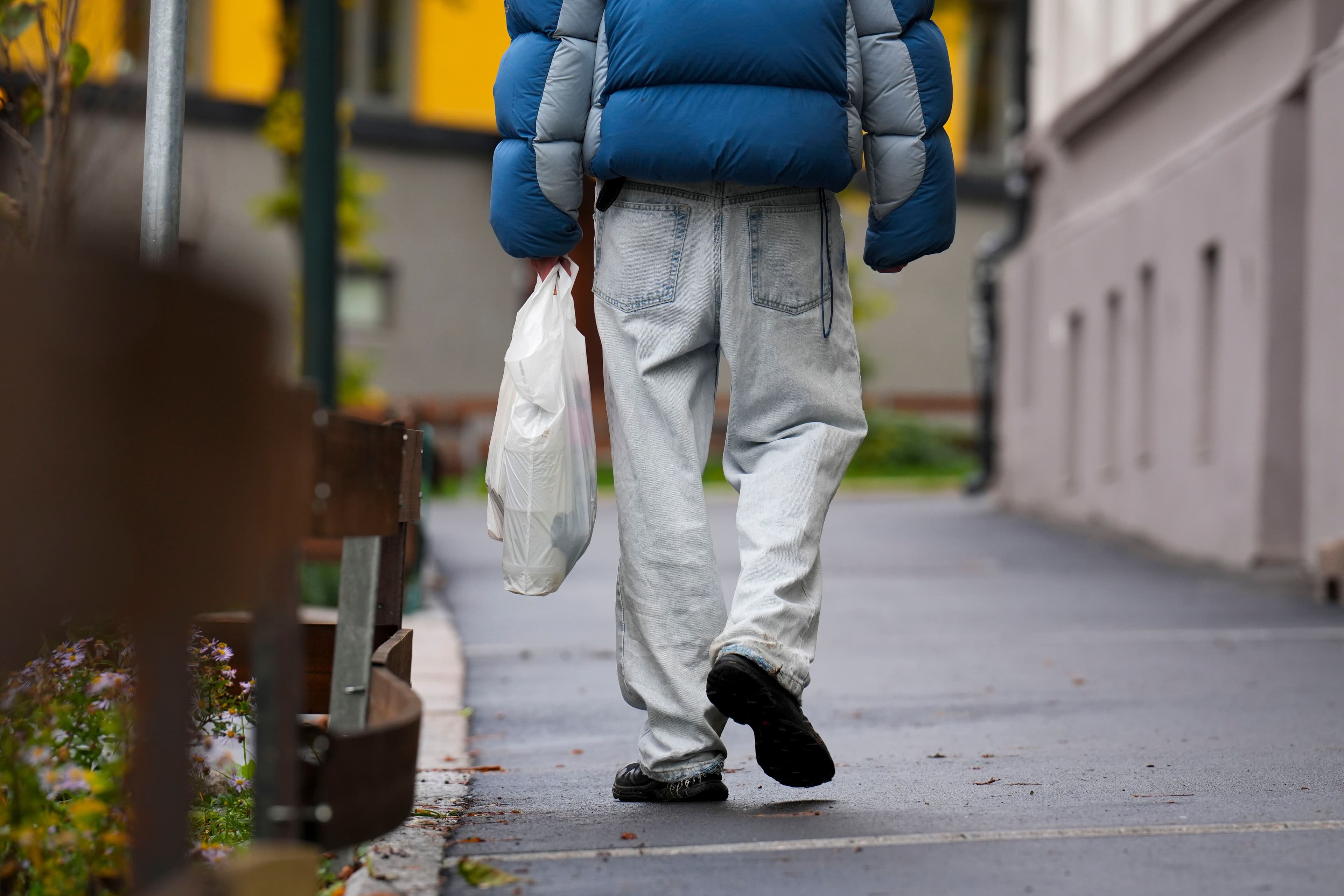 Mann går med plastpose